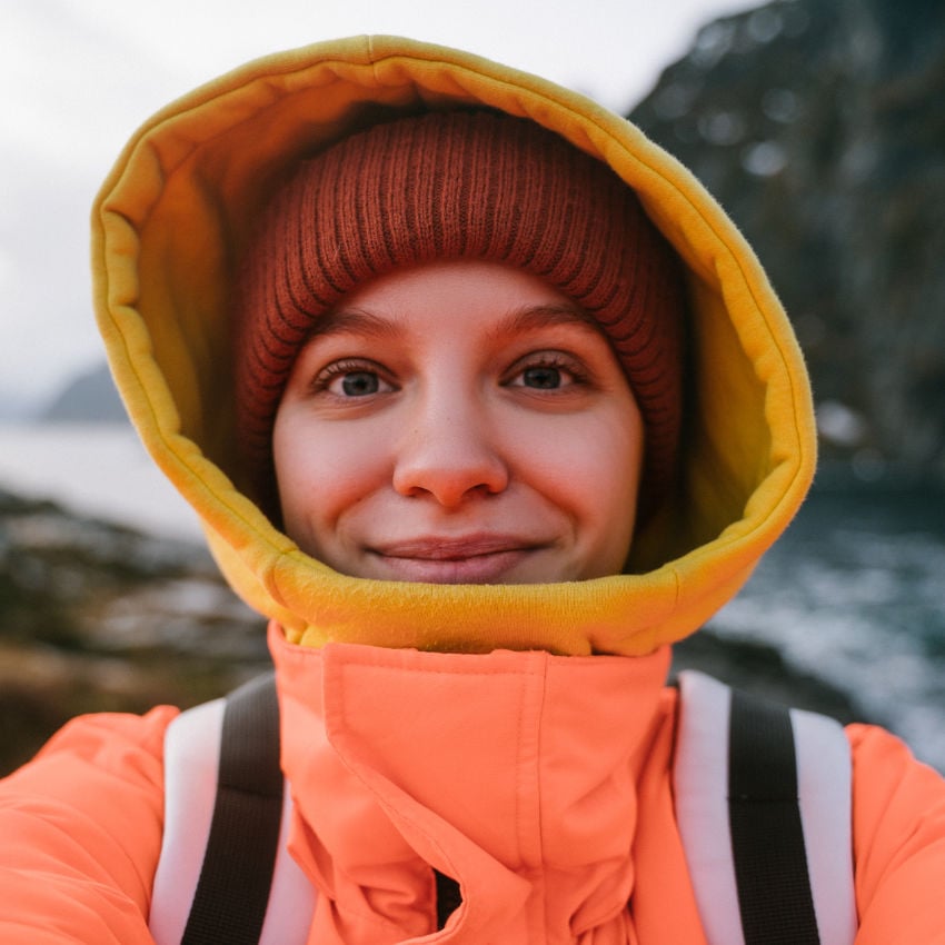 Touristin mit Regenjacke nimmt ein Selfie von sich auf