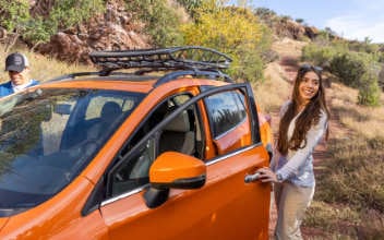 checkliste-auto_352x220_2024_04 Frau steht neben Geländewagen mit geöffneter Tür