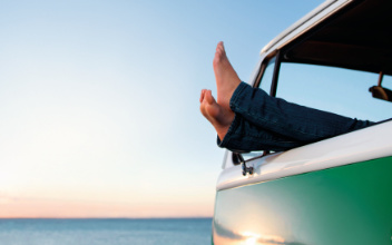 Füße hängen aus Fahrerfenster eines Camperbullis