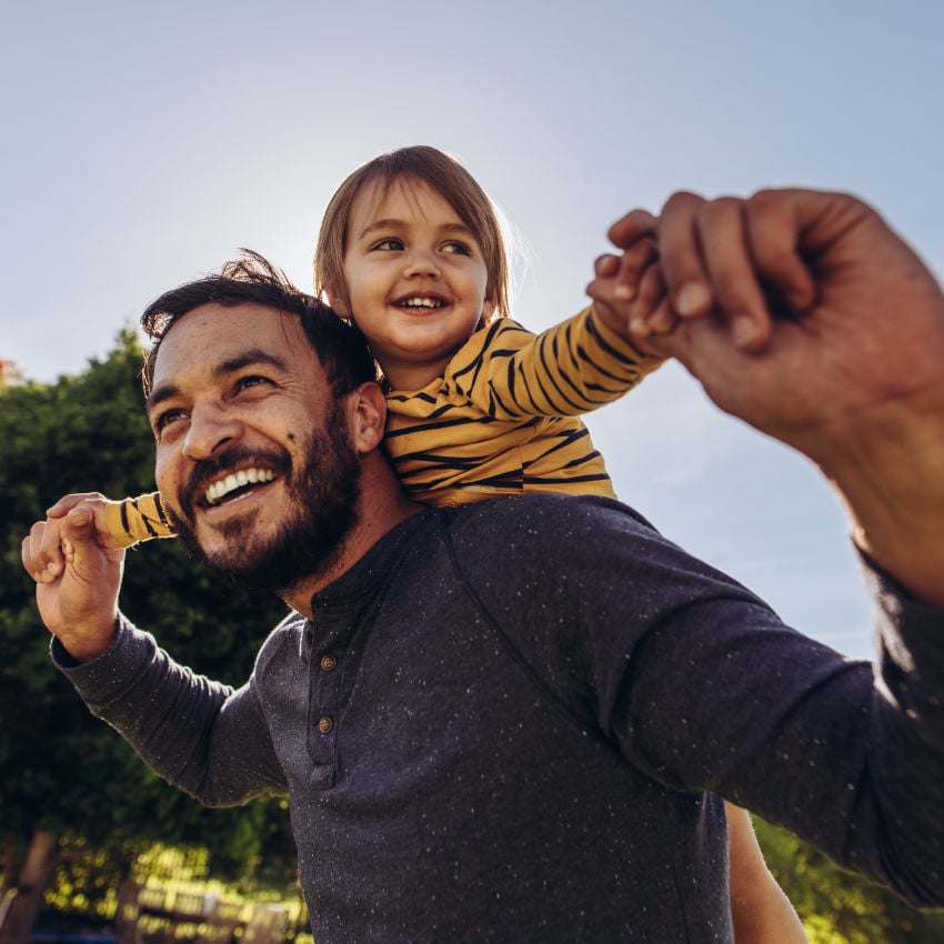 Mann trägt Jungen auf seinen Schultern