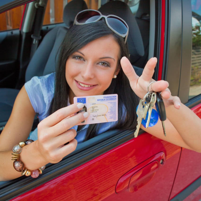 Junge Frau zeigt stolz ihren Führerschein