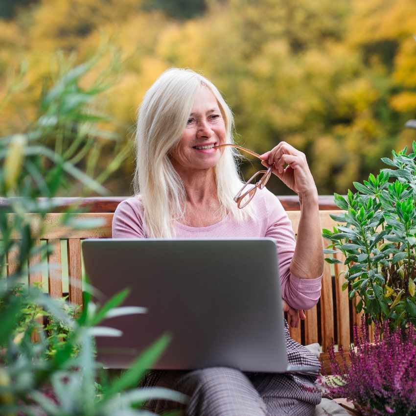 Frau mit Laptop in Garten
