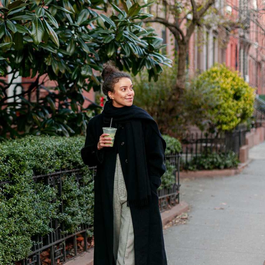 _gabrielflores-proposal-59142-600b2693aea47-ge0a6370 Junge Frau läuft mit einem Getränk auf einem Gehweg