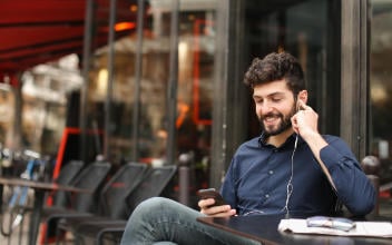 hpv-leistungen_352x220_2023_08 Mann lächelt beim Telefonieren in sein Handy