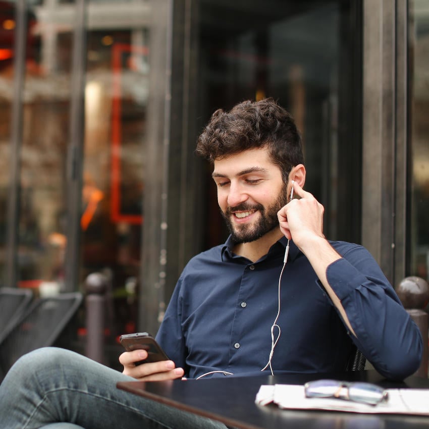 Mann lächelt beim Telefonieren in sein Handy