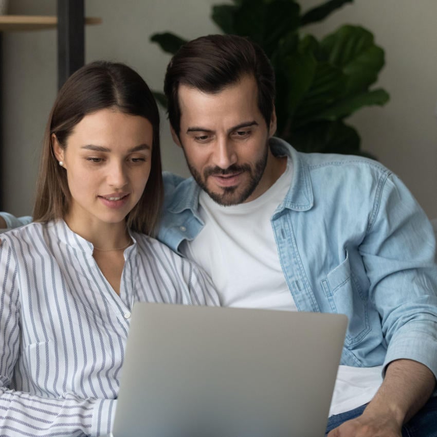 2DE4W7Y_850x850 Mann und Frau blicken gemeinsam auf Laptop