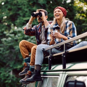 individualreise_300x300_2024_12 Pärchen sitzt mit Fernglas auf Campingmobil
