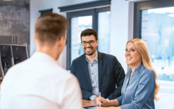 Mitarbeitende unterhalten sich an Stehtisch