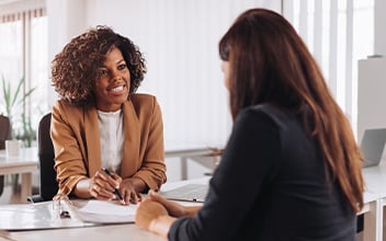 investmentfonds_352x220_2024_07 Zwei Frauen sitzen sich gegenüber am Tisch