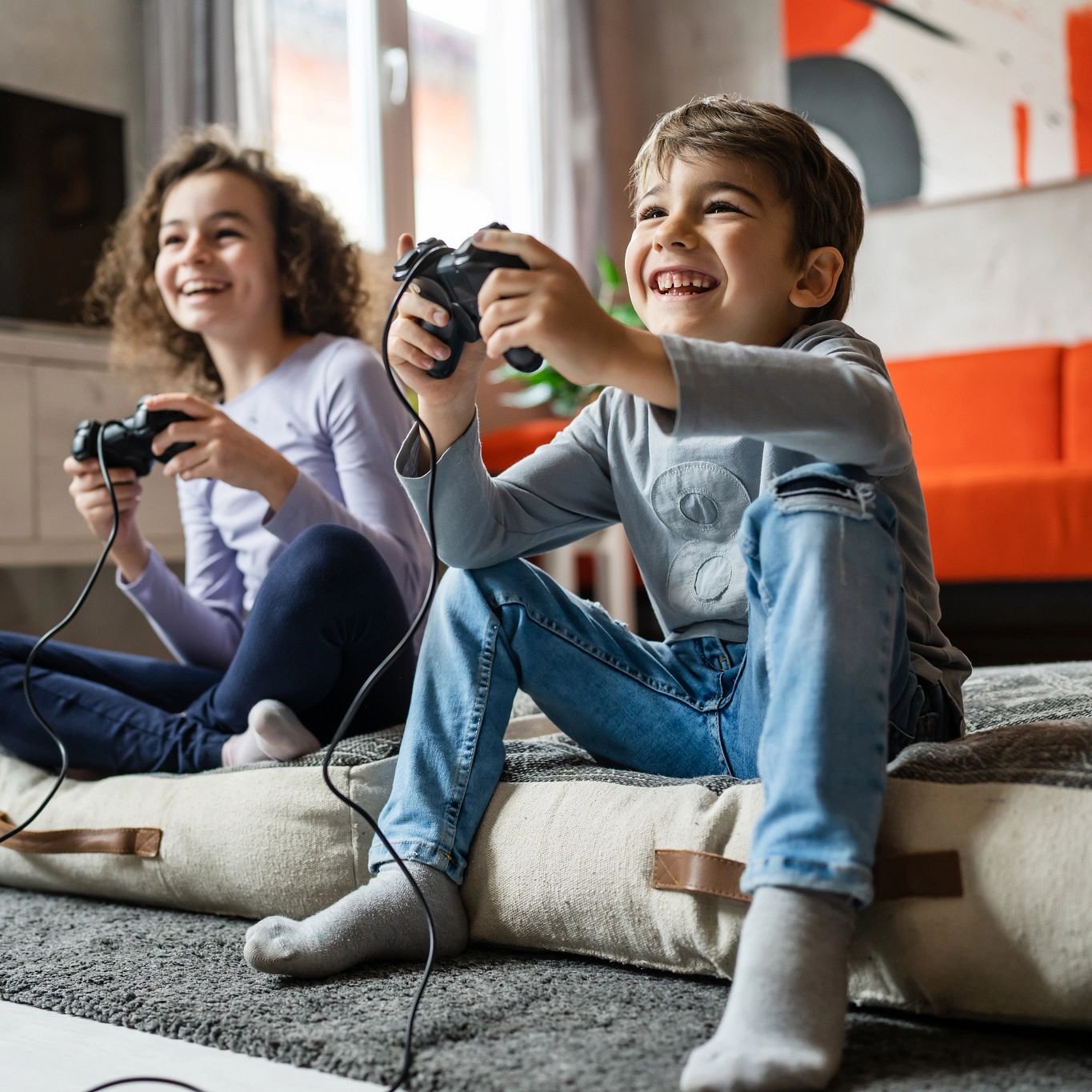 zwei Kinder spielen an einer Fernseh-Konsole