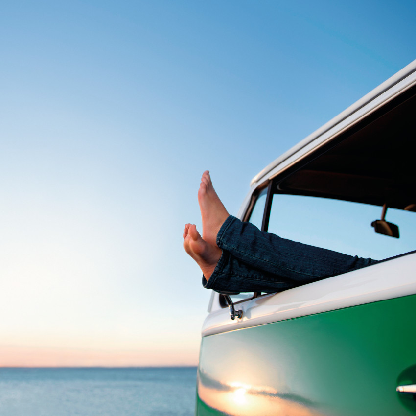 Füße hängen aus Fahrerfenster eines Camperbullis