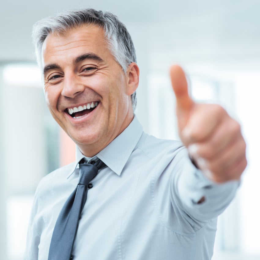 G1DX6C_850x850 Fröhlicher Geschäftsmann, der lächelnd einen Daumen nach oben streckt
