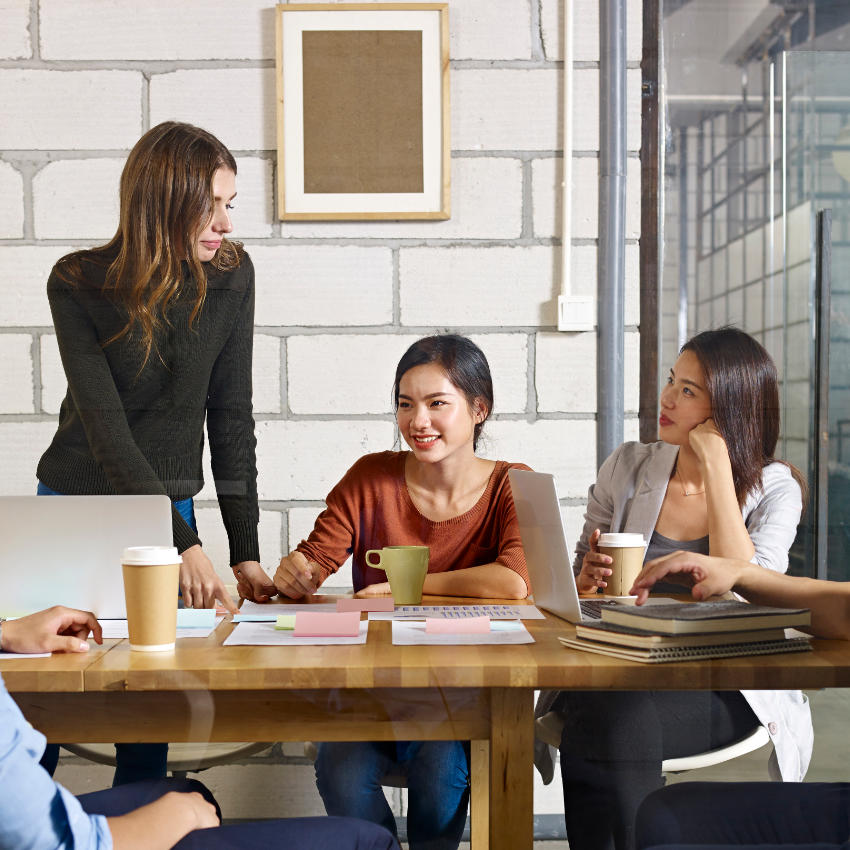 Mitarbeitende mit Kafee und Laptop