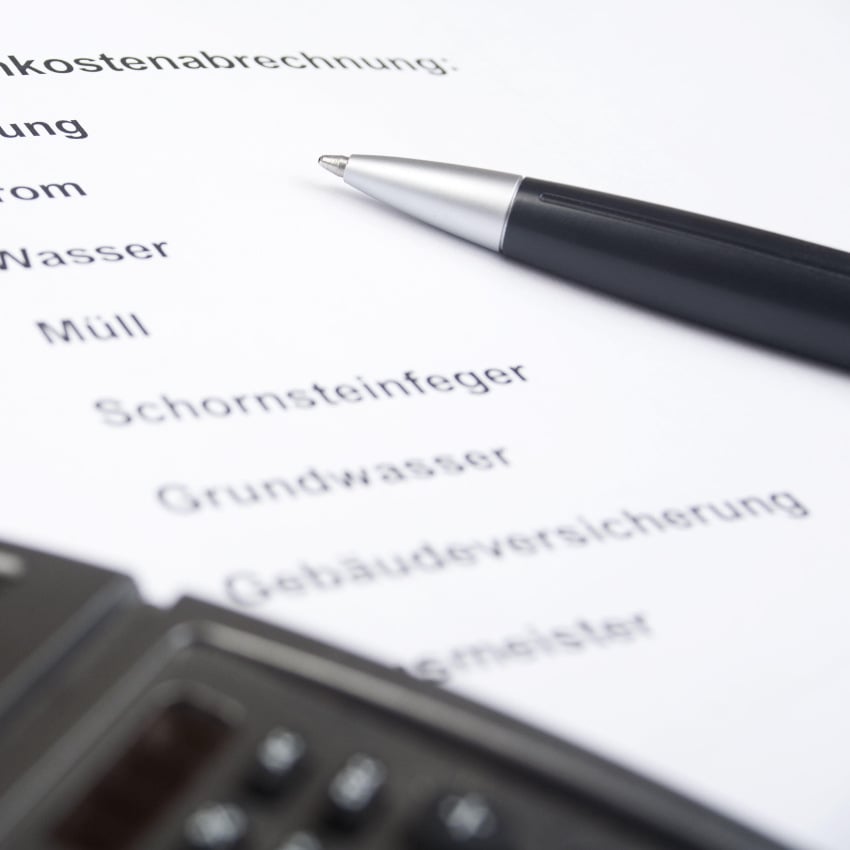 Nebenkostenabrechnung mit Kugelschreiber und Taschenrechner