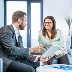 professionelle-kundenberatung_300x300_2024_06 junger Mann, der an einem Laptop arbeitet, lächelt in die Kamera