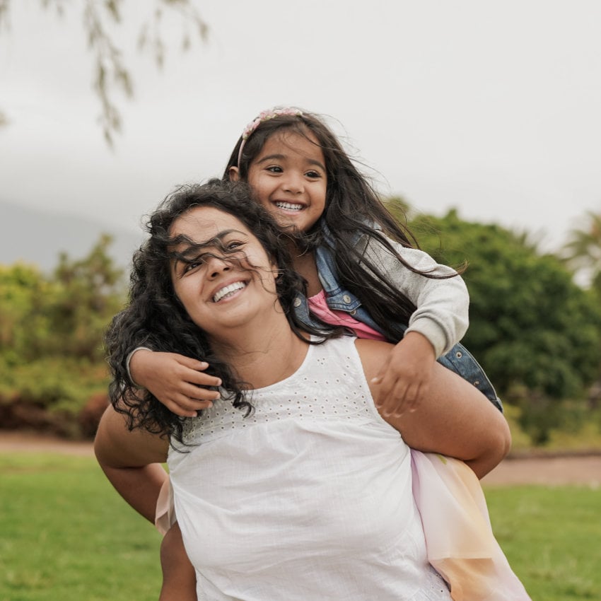 Mutter trägt ihre Tochter Huckepack Mutter trägt ihre Tochter Huckepack