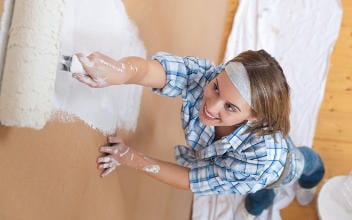 schoenheitsreparaturen_352x220_2023_10 Frau beim Streichen einer Wand