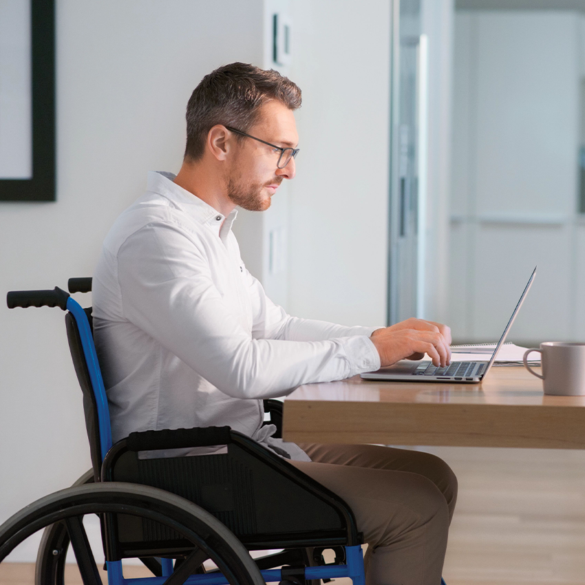 Mann im Rollstuhl vor einem Schreibtisch