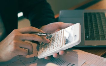 Mann benutzt Taschenrechner