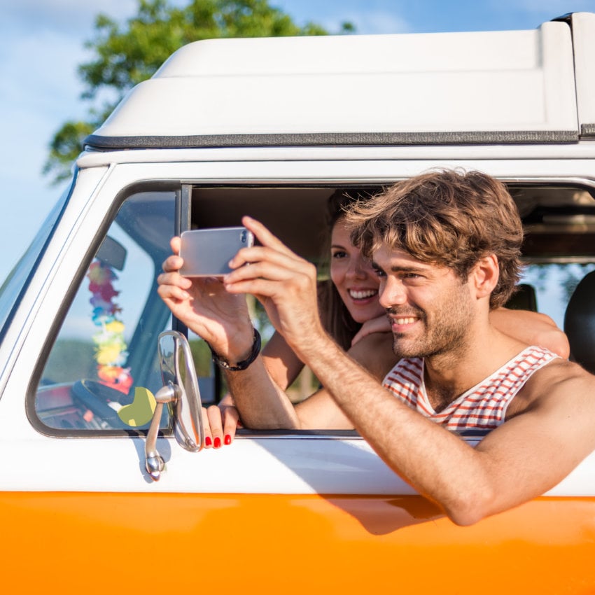wohnmobil-zulassung_850x850_2024_03 junger Mann knipst mit dem Handy aus seinem Wohnmobil