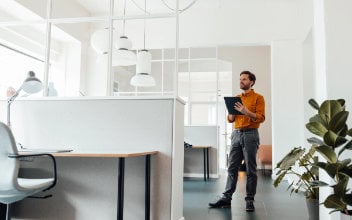 wohnungsuebergabe_352x220_2023_11 Mann mit Dokument in einer hellen Wohnung