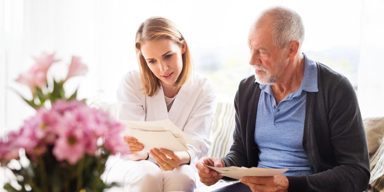 Frau und älterer Mann lesen ein Schreiben