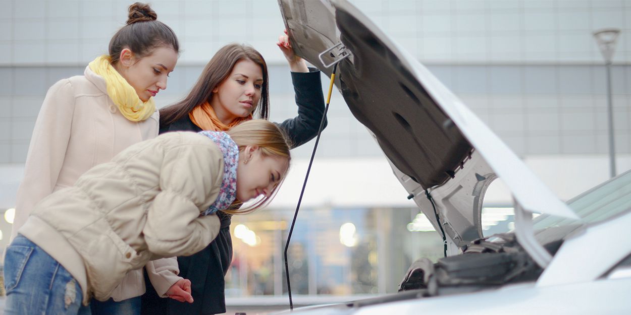 Frauen über Automotor gebeugt