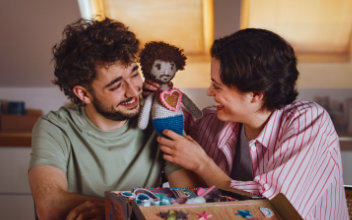 Mann im und Frau mit gehäkelter Puppe