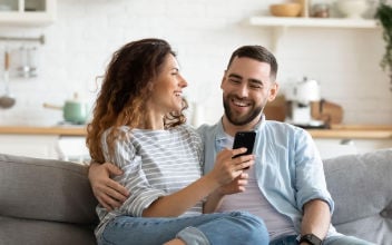 hpv-kosten_352x220_2023_08 Fröhliches Pärchen auf Sofa