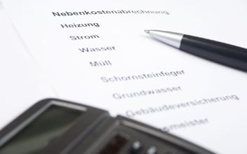 nebenkostenabrechnung_352x220_2023_10 Nebenkostenabrechnung mit Kugelschreiber und Taschenrechner